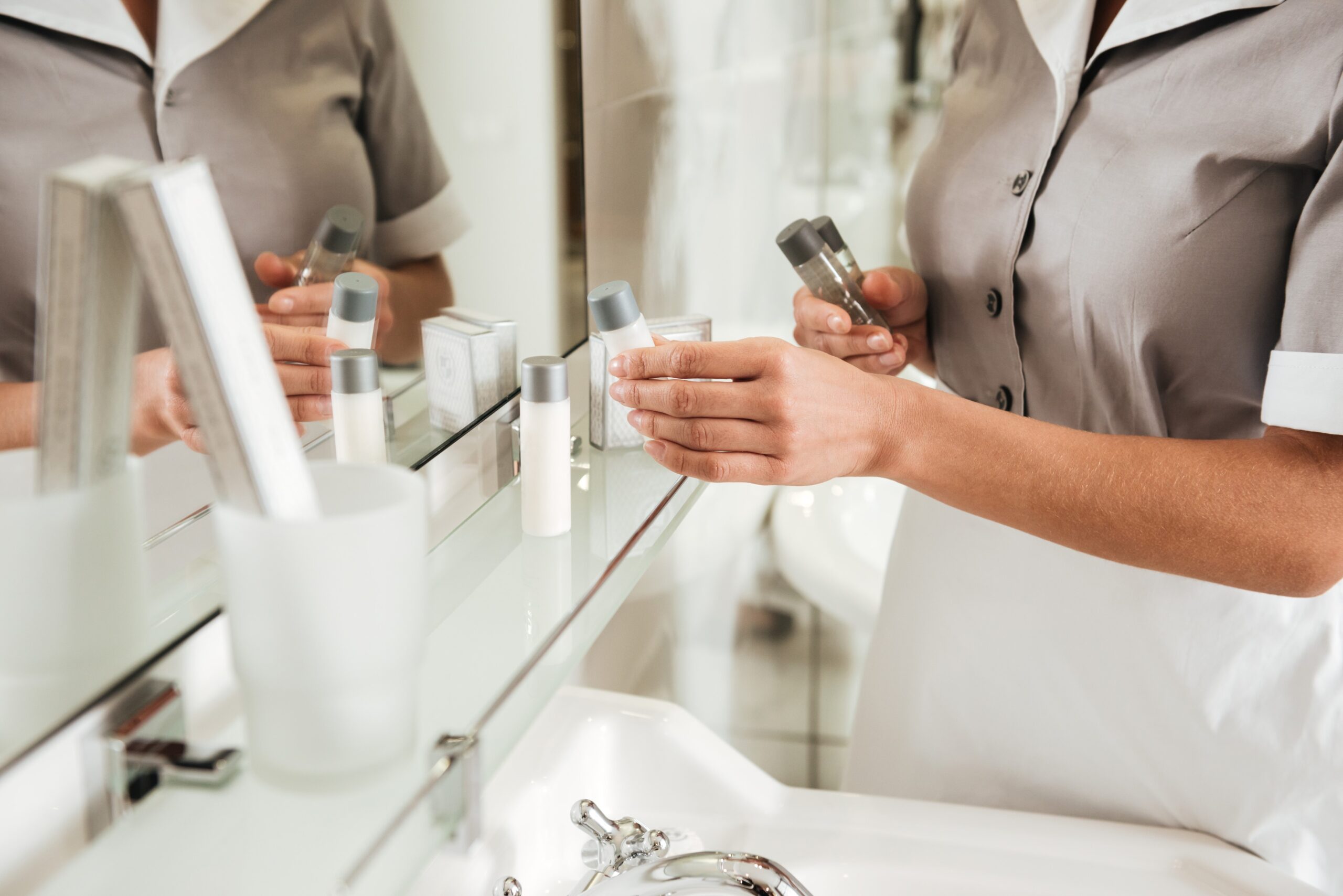 Cropped image of a young hotel maid putting bath accessories in a bathroom